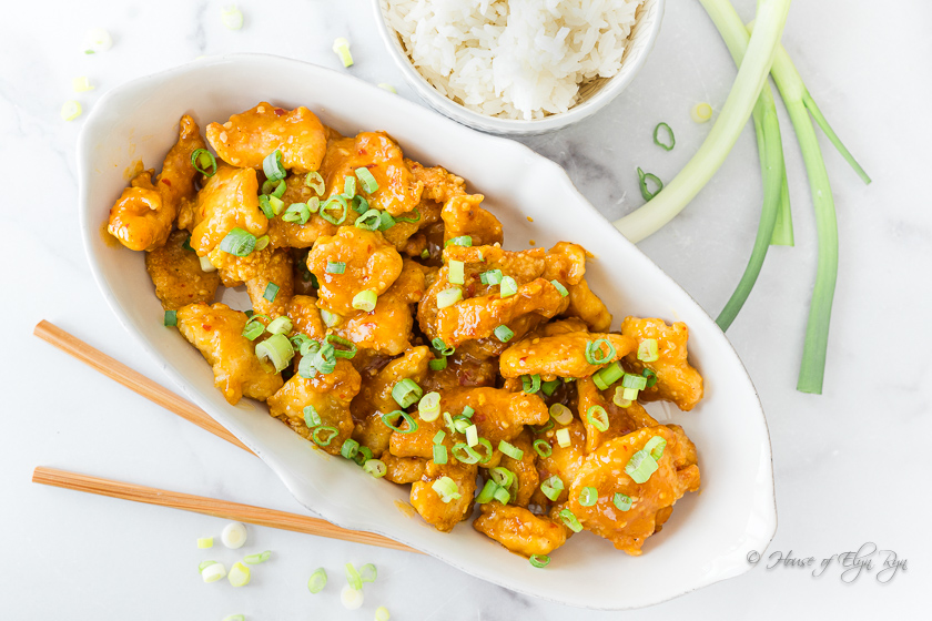 A dish of Orange Chicken sprinkled with green onions.