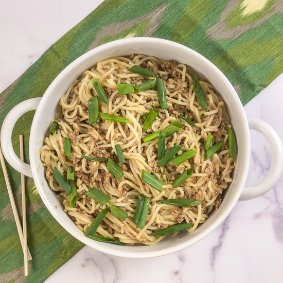 A dish with dan dan noodles and green onions